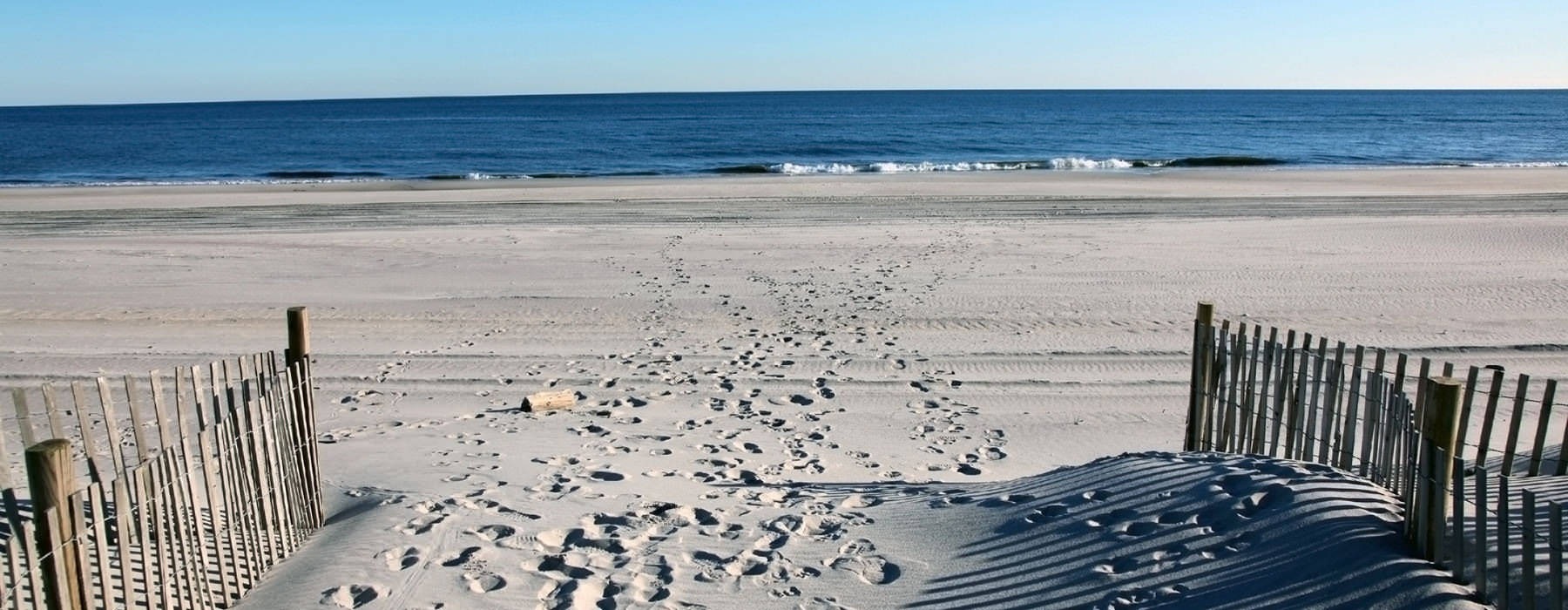 Footprints leading to ocean in the sand
